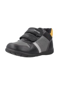 Chaussure de tout-petit noire et grise avec une tige en cuir lisse, deux bandes Velcro, une semelle texturée et un accent jaune au talon.