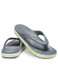 Paire de tongs Crocs grises avec des accents vert citron, semelle texturée et logo Crocs sur la sangle et le bord de la semelle.