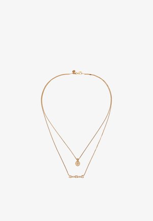 Zarte, mehrlagige Halskette aus Gold mit einem runden Anhänger mit floralem Muster und einem horizontalen Stabanhänger mit kleinen Steinen.
