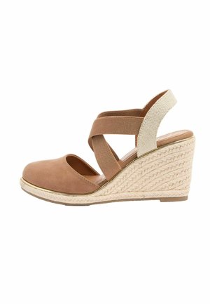 Sandale platformă cu talpă wedge de culoare taupe, platformă din iută împletită, bretele elastice încrucișate și vârf închis pe un fundal alb.