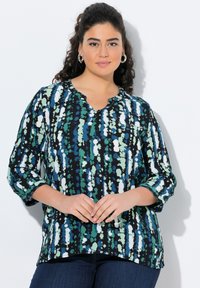 Maglietta plus-size in nero, verde e blu con motivo astratto. Presenta un collo rotondo, maniche a tre quarti e tessuto morbido.
