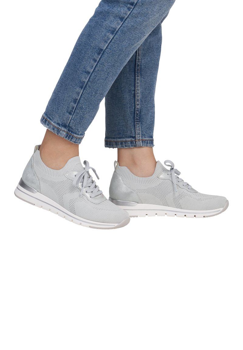 Hellgraue Sportschuhe mit einem Strickobermaterial, textilen Details und einer glatten Gummisohle. Sie verfügen über eine Schnürung und einen gepolsterten Fersenbereich.
