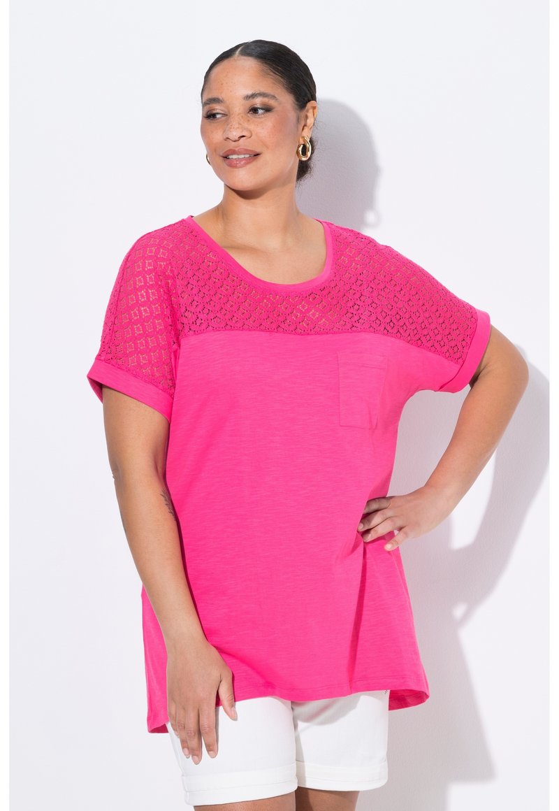 Růžový top s krátkými rukávy s krajkovým vzorem na přední části a s kapsou. Měkká textura a uvoln�ěný střih. Spárováno s bílými šortkami.
