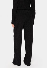 Svarta, långbyxor med vida ben och en subtil texturerad glans, som har en elastisk midja och avslappnad passform, lämpliga för avslappnad användning.