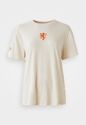 Bežinė medvilninė marškinė su apvalia iškirpte. Yra oranžinė liūto emblema ant krūtinės ir oranžinis logotipas ant rankovės. Trumpomis rankovėmis.