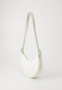 Weiße Leder-Schultertasche mit einer geschwungenen Form, langem verstellbarem Träger und einer rechteckigen Fronttasche. Glatte Textur und minimales Zubehör.