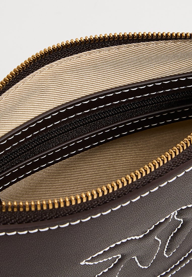 Primo piano di una borsa in pelle marrone con zip dorata, fodera in tessuto beige, una tasca con zip nera e dettagli in cucitura bianca.
