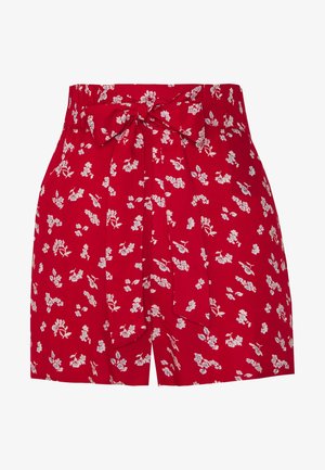Shorts rouges taille haute avec un motif floral blanc et bleu et une ceinture en tissu assortie nouée en nœud à la taille.