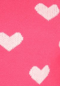 Tessuto a maglia rosa con un motivo di cuori bianchi, di varie dimensioni, con una texture morbida e cuciture uniformi in tutto il tessuto.