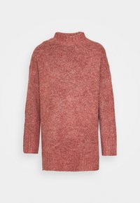 Roter Strickpullover mit hohem Kragen, langen Ärmeln, geripptem Material und seitlichen Schlitzen, der einen weichen, gemütlichen Eindruck vermittelt.
