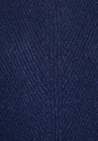 Tessuto di colore blu scuro con una trama a motivo spina di pesce sottile, che mostra fibre intrecciate fini e linee diagonali a zigzag.