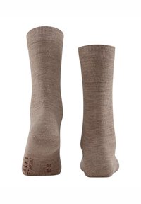 Calze alla caviglia marroni in materiale morbido e testurizzato, con bordo a coste e punta rinforzata. Il nome del marchio è stampato in rosso.