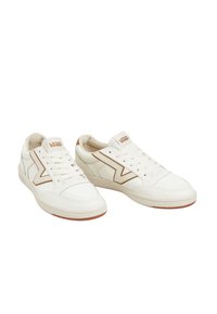 Sneakers bianchi con una tomaia in pelle liscia, accenti marroni a contrasto, punta perforata e suola in gomma naturale testurizzata. Design con lacci.