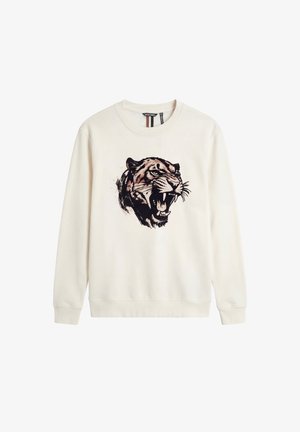 Sudadera de manga larga color crema con un gráfico detallado en el pecho de una cabeza de tigre rugiente en negro y marrón, cuello redondo y puños acanalados.