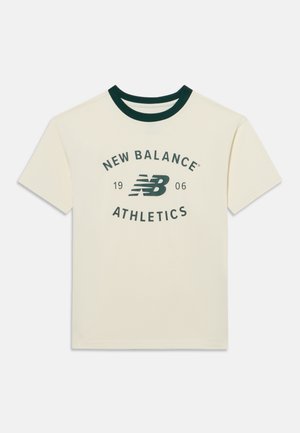T-shirt à manches courtes couleur crème avec col vert foncé et logo "New Balance Athletics 1906" imprimé en vert foncé sur le devant.