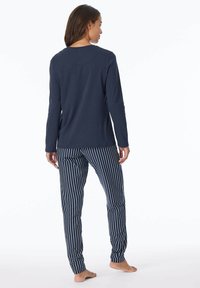 Navyblaues Langarmoberteil mit Rundhalsausschnitt und gestreiften Schlafanzughosen in Navy und Weiß. Baumwollmaterial; lässige Passform.