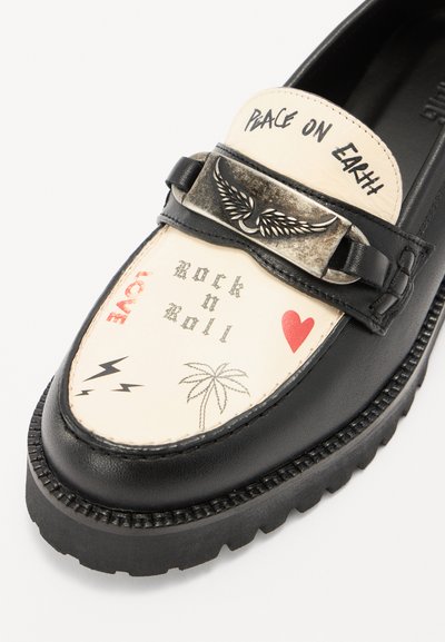 Black leather loafer with a beige patterned upper, featuring graphics like "peace on earth," palm trees, hearts, and lightning bolts. Metallic buckle detail.