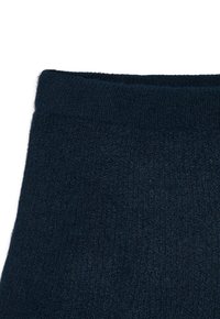 Donker marineblauw gebreide stof met een zachte, pluizige textuur en een geribde tailleband.