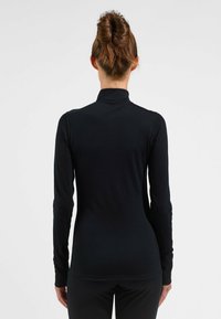 Schwarzes, langärmliges Turtleneck-Oberteil aus einem glatten, dehnbarem Stoff. Verfügt über eine figurbetonte Silhouette und einen hohen Kragen ohne sichtbare Branding.