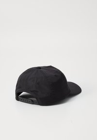 Casquette noire en matériau léger. Dotée d'une couronne arrondie, d'un visière courbée et d'une fermeture snapback réglable. Texture lisse, design minimal.