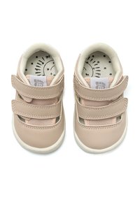 Zapatos de niño pequeño en beige claro con dos tiras de Velcro, cuero texturizado y un interior acolchado suave que presenta un gráfico de sol en la plantilla.