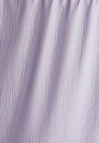 Tissu lavande texturé avec une surface froissée, présentant un motif ondulé qui ajoute de la profondeur et de l'intérêt visuel.