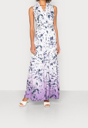 Ærmeløs maxikjole med V-hals og hvidt, sort og lilla blomsterprint, bælte i taljen, båret med hvide åbne hæle.