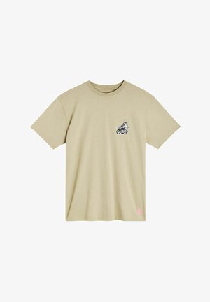 T-shirt en coton vert olive avec un petit graphique noir représentant une figure caricaturale sur une moto, avec du texte rose en bas.