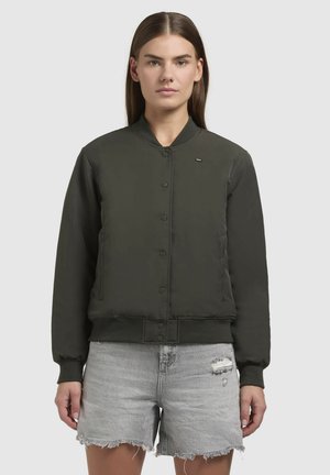 Groene bomberjack met een gladde afwerking, voorzichtige drukknoopsluiting, en ribgebreide manchetten en onderrand. Gecombineerd met versleten grijze denim shorts.