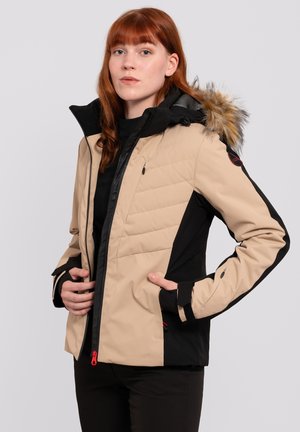 Beige and black winter jacket with quilted texture, front zipper, side pockets, and fur-lined hood. Features adjustable cuffs and logo patch.