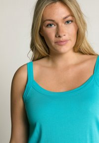 Türkises Tanktop mit breiten Trägern, glatter Textur und rundem Ausschnitt, ausgestattet mit einem taillierten Design und gleichmäßigen Nähdetails.