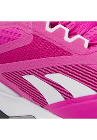 Růžová sportovní bota s horní částí z síťoviny, semišovými doplňky a bílým proužkovaným logem na boku, s texturovanými detaily a gumovou podrážkou.