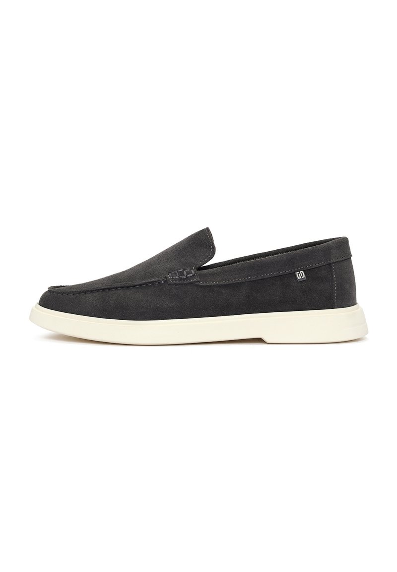 Zapatillas sin cordones de ante gris oscuro, con punta redondeada, suela blanca y un detalle de costura mínima en la parte superior y los lados. Sin marcas visibles.