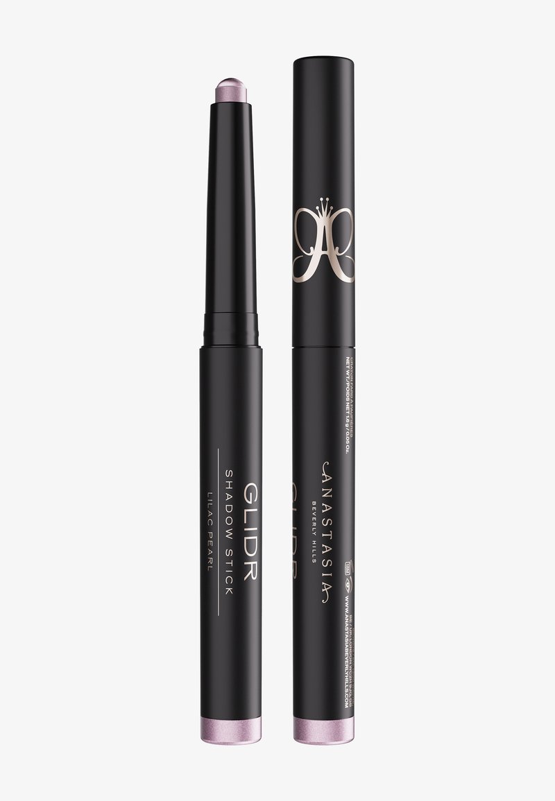 Deux sticks à fards à paupières cylindriques noirs, l'un ouvert montrant une couleur lilas nacrée, étiqueté "Glider Shadow Stick" par Anastasia Beverly Hills.
