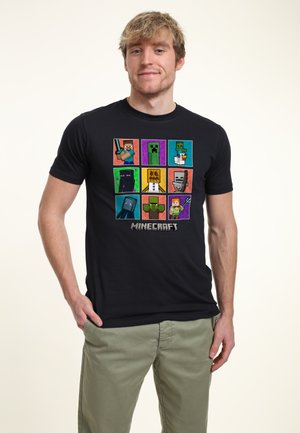 Black cotton t-shirt featuring a colorful Minecraft-themed graphic with pixelated characters arranged in a grid pattern.