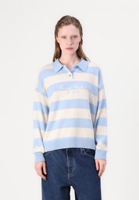 Light blue and cream striped sweater with a collar, featuring embroidered text on the front and ribbed cuffs and hem.
