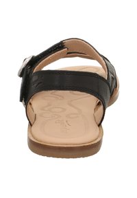Schwarze Leder-Sandale mit verstellbarem Riemen, flacher Sohle, heller brauner Innensohle mit strukturiertem Muster und silberfarbenen Hardware-Akzenten.