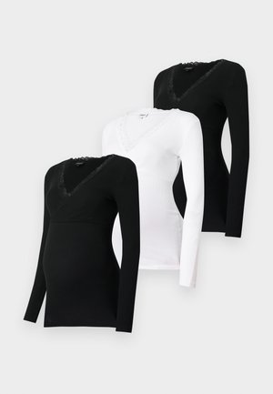 Drie langmouw tops in zwart en wit, met een V-hals en kantafwerking langs de halslijn. Zachte, rekbare stof ideaal voor comfort.