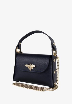 Sac à main en cuir bleu marine avec une poignée supérieure et un emblème de abeille doré. Il dispose d'une bandoulière en chaîne et d'accents ronds dorés sur les côtés. La texture est granuleuse.
