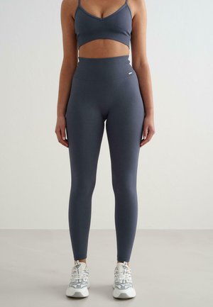 Graues, geripptes Sport-BH- und hochtailliertes Leggings-Set mit einem kurzen Design, weichem Material und kontrastierendem weißen Logo-Detail.