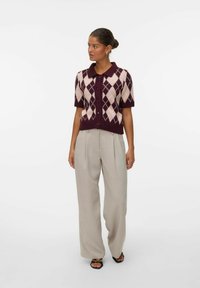 Polo en tricot à manches courtes, bordeaux avec un motif de losanges crème, comportant cinq boutons et un col, assorti à un pantalon large gris clair.