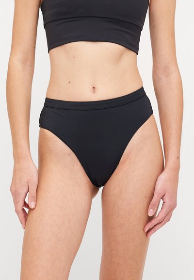 Augstās jostas melnas bikini apakšdaļas, kas izgatavota no elastīgas tkanas ar gludu faktūru. Ir vienkāršs dizains un plats elastīgs jostasvieds.