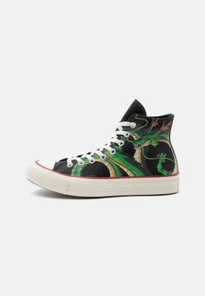 Schwarzer High-Top-Sneaker mit weißen Schnürsenkeln und Sohle, mit einer leuchtend grünen Drachengrafik an der Seite und rotem Besatz über der Sohle.