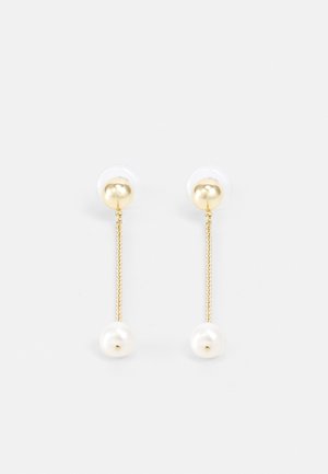 Boucles d'oreilles clous en or avec une fine chaîne pendante se terminant par des perles blanches rondes, sur fond blanc.