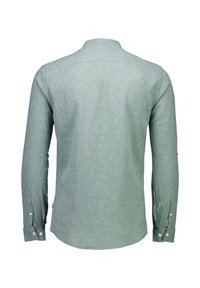 Camisa verde de manga larga con una textura suave, puños abotonados, un yugo en la parte posterior y un diseño de corte relajado. Detalles mínimos y tela ligera.