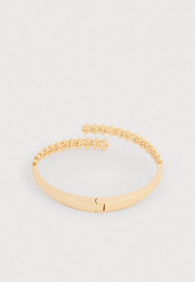 Kuldse tooniga käevõru, millel on sile rihm koos hingega sulgemisega ja pärlikee jaotis pealmisel osal, luues tekstuurse mustri.