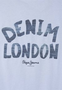 Bílé tričko s metalicky modrým textem "DENIM LONDON" a výrazným, hravým písmem. Malé logo "Pepe Jeans" v černé barvě pod ním. Hladká textura.
