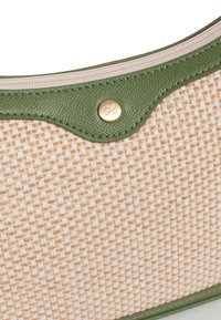 Borsa in tessuto beige texture intrecciata con dettagli in pelle verde, dotata di un bottone a scatto dorato e una chiusura con zip nella parte superiore.