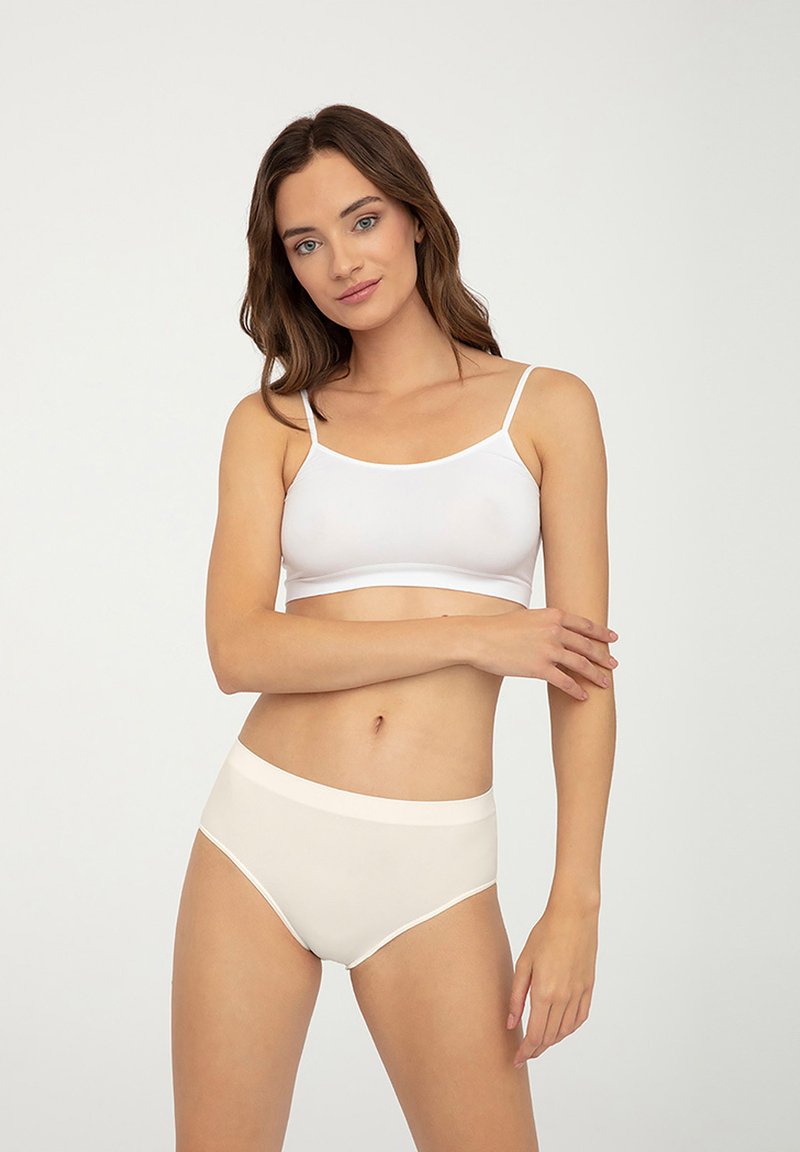 Biały bawełniany biustonosz braletka z cienkimi ramiączkami oraz kremowe majtki w wysokim stanem, oba z gładką fakturą i prostym wzornictwem.