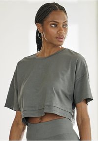 Cropped gray T-shirt in soft fabric, featuring a crew neckline and short sleeves. Subtle "LA" logo stitched on the front.
